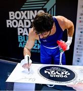 11 March 2024; Patrick Brown of Great Britain signs a promotional board after qualifying for the Olympics after winning their Men's 92kg Quarterfinals bout against Mateusz Bereznicki of Poland during day nine at the Paris 2024 Olympic Boxing Qualification Tournament at E-Work Arena in Busto Arsizio, Italy. Photo by Ben McShane/Sportsfile