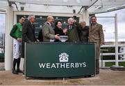 13 March 2024; Jockey Patrick Mullins, left, and trainer Willie Mullins, third from right, celebrates with winning connections after Jasmin De Vaux won the Weatherbys Champion Bumper on day two of the Cheltenham Racing Festival at Prestbury Park in Cheltenham, England. Photo by David Fitzgerald/Sportsfile