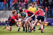 14 March 2024; Oscar He of St Gerard's School is tackled by Christian Shortall, Louis Murphy and Luke O'Shea of CUS during the Bank of Ireland Father Godfrey Cup final match between CUS and St Gerard's School at Energia Park in Dublin. Photo by Ben McShane/Sportsfile