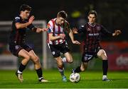 15 March 2024; Daniel Kelly of Derry City in action against James Clarke, left, and Paddy Kirk of Bohemians during the SSE Airtricity Men's Premier Division match between Bohemians and Derry City at Dalymount Park in Dublin. Photo by Tyler Miller/Sportsfile