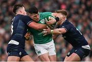 16 March 2024; Calvin Nash of Ireland is tackled by Huw Jones, left, and Kyle Steyn of Scotland during the Guinness Six Nations Rugby Championship match between Ireland and Scotland at the Aviva Stadium in Dublin. Photo by Brendan Moran/Sportsfile