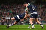16 March 2024; Robbie Henshaw of Ireland is tackled by Finn Russell, left, and George Turner of Scotland during the Guinness Six Nations Rugby Championship match between Ireland and Scotland at the Aviva Stadium in Dublin. Photo by Harry Murphy/Sportsfile