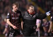 15 March 2024; Cian Byrne of Bohemians leaves the pitch to receive medical attention with Bohemians doctor Fiona Dennehy during the SSE Airtricity Men's Premier Division match between Bohemians and Derry City at Dalymount Park in Dublin. Photo by Stephen McCarthy/Sportsfile