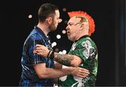 21 March 2024; Luke Humphries, left, and Peter Wright embrace after their match at the BetMGM Premier League Darts at the 3Arena in Dublin. Photo by Ben McShane/Sportsfile