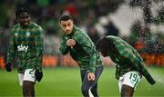 26 March 2024; Republic of Ireland players, from left, Festy Ebosele, Adam Idah and Michael Obafemi dodge a water sprinkler before the international friendly match between Republic of Ireland and Switzerland at the Aviva Stadium in Dublin. Photo by Ben McShane/Sportsfile