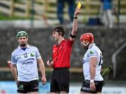 31 March 2024; Luke Hands of Warwickshire, right, is shown a yellow card by referee Conor Daly during the Allianz Hurling League Division 3B Final match between Fermanagh and Warwickshire at St Joseph's Park in Ederney, Fermanagh. Photo by Sam Barnes/Sportsfile