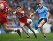 31 March 2024; Colm Basquel of Dublin scores a point despite the efforts of Paul Cassidy of Derry during the Allianz Football League Division 1 Final match between Dublin and Derry at Croke Park in Dublin. Photo by John Sheridan/Sportsfile