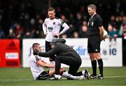 1 April 2024; Zak Johnson of Dundalk is treated for an injury by Dundalk physiotherapist Danny Miller, as John Mountney of Dundalk and referee Paul McLaughlin look on, during the SSE Airtricity Men's Premier Division match between Dundalk and Drogheda United at Oriel Park in Dundalk, Louth. Photo by Ben McShane/Sportsfile