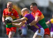 7 April 2024; Kevin O'Grady of Wexford passes the ball while under pressure from Colm Hulton of Carlow during the Leinster GAA Football Senior Championship Round 1 match between Wexford and Carlow at Chadwicks Wexford Park in Wexford. Photo by Tyler Miller/Sportsfile