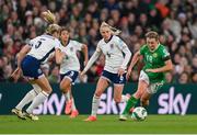 9 April 2024; Kyra Carusa of Republic of Ireland in action against Leah Williamson and Alex Greenwood of England during the UEFA Women's European Championship qualifying group A match between Republic of Ireland and England at Aviva Stadium in Dublin. Photo by Stephen McCarthy/Sportsfile