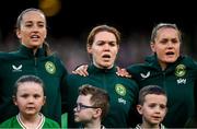 9 April 2024; Republic of Ireland players, from left, Anna Patten, Aoife Mannion and Heather Payne sing the National Anthem before the UEFA Women's European Championship qualifying group A match between Republic of Ireland and England at Aviva Stadium in Dublin. Photo by Stephen McCarthy/Sportsfile