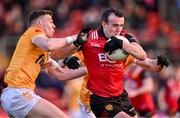 13 April 2024; Conor McCrickard of Down is tackled by Declan Lynch of Antrim during the Ulster GAA Football Senior Championship quarter-final match between Down and Antrim at Páirc Esler in Newry, Down. Photo by Ben McShane/Sportsfile