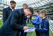 13 April 2024; Rob Russell of Leinster signs autographs for  Matchday mascot Daragh De Búrca before the Investec Champions Cup quarter-final match between Leinster and La Rochelle at the Aviva Stadium in Dublin. Photo by Harry Murphy/Sportsfile