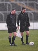 14 April 2024; Referee Seán Lonergan, left, and linesman Barry Tiernan wait in the rain for the teams to return to the pitch for the second half of the Leinster GAA Football Senior Championship quarter-final match between Kildare and Wicklow at Laois Hire O’Moore Park in Portlaoise, Laois. Photo by Piaras Ó Mídheach/Sportsfile
