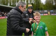 14 April 2024; Fionn Brewster, representing Fermanagh Cumann na mBunscol, grandson of Michael Brewster, who Brewster Park is named after, and son of former Fermanagh player Tom Brewster, receives his medal from Ulster GAA President Ciaran McLaughlin, during the Ulster GAA Football Senior Championship quarter-final match between Fermanagh and Armagh at Brewster Park in Enniskillen, Fermanagh. Photo by Ramsey Cardy/Sportsfile