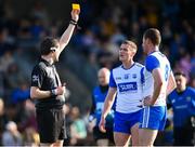 20 April 2024; Referee David Murnane shows a yellow card to Michael Curry of Waterford, right, as team-mate Sean Whelan-Barrett protests during the Munster GAA Football Senior Championship semi-final match between Waterford and Clare at Fraher Field in Dungarvan, Waterford. Photo by Tyler Miller/Sportsfile