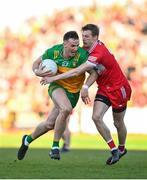 20 April 2024; Jason McGee of Donegal in action against Brendan Rogers of Derry during the Ulster GAA Football Senior Championship quarter-final match between Derry and Donegal at Celtic Park in Derry. Photo by Seb Daly/Sportsfile