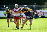21 April 2024; Shauna Mac Sweeney of Wexford in action against Eimear Murray of Derry during the Electric Ireland All-Ireland Camogie Minor A Shield semi-final match between Derry and Wexford at Clane in Kildare. Photo by Daire Brennan/Sportsfile