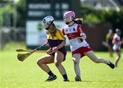21 April 2024; Orla O’Rourke of Wexford in action against Ellie Griffin of Derry during the Electric Ireland All-Ireland Camogie Minor A Shield semi-final match between Derry and Wexford at Clane in Kildare. Photo by Daire Brennan/Sportsfile