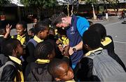 25 April 2024; Ahead of their game on Saturday in the BKT United Rugby Championship, Leinster Rugby and DHL Stormers players, coaches and staff visited and took part in a rugby session in Zimasa Primary School, pictured is Leinster elite player development officer Kieran Hallett with students at Zimasa Primary School in Lunga, Cape Town. Photo by Harry Murphy/Sportsfile