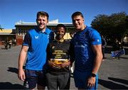 25 April 2024; Ahead of their game on Saturday in the BKT United Rugby Championship, Leinster Rugby and DHL Stormers players, coaches and staff visited and took part in a rugby session in Zimasa Primary School, pictured is Leinster players Lee Barron and Aitzol King with a student at Zimasa Primary School in Lunga, Cape Town. Photo by Harry Murphy/Sportsfile