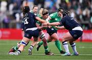 27 April 2024; Sam Monaghan of Ireland is tackled by Emma Wassell, left, and Molly Wright of Scotland during the Women's Six Nations Rugby Championship match between Ireland and Scotland at the Kingspan Stadium in Belfast. Photo by Ben McShane/Sportsfile