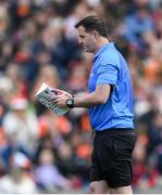 27 April 2024; Linesman Sean Hurson reads the match programme before the Ulster GAA Football Senior Championship semi-final match between Down and Armagh at St Tiernach's Park in Clones, Monaghan. Photo by Stephen McCarthy/Sportsfile