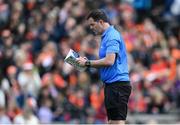 27 April 2024; Linesman Sean Hurson reads the match programme before the Ulster GAA Football Senior Championship semi-final match between Down and Armagh at St Tiernach's Park in Clones, Monaghan. Photo by Stephen McCarthy/Sportsfile