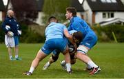 29 April 2024; Caelan Doris is tackled by Rónan Kelleher and Joe McCarthy during Leinster rugby squad training at UCD in Dublin. Photo by Brendan Moran/Sportsfile