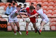 1 May 2024; Niall O'Donnell of Derry is tackled by Ronan Cassidy, left, and Conor Devlin of Tyrone during the EirGrid Ulster GAA U20 Football Championship Final match between Derry and Tyrone at the Box-It Athletic Grounds in Armagh. Photo by Ben McShane/Sportsfile
