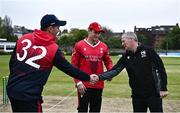 2 May 2024; Mark Adair of Northern Knights shakes hands with Match referee Graham McCrea alongside PJ Moor of Munster Reds before the Cricket Ireland Inter-Provincial Trophy match between Munster Reds and Northern Knights at Pembroke Cricket Club in Dublin. Photo by Harry Murphy/Sportsfile