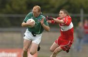 24 July 2004; John Quane, Limerick, is tackled by Derry's Jason Stokes. Bank of Ireland Senior Football Championship Qualifier, Round 4, Derry v Limerick, Dr. Hyde Park, Roscommon. Picture credit; Pat Murphy / SPORTSFILE