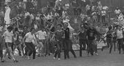 10 July 1983; Cork supporters run onto the pitch to celebrate victory as Waterford captain Seamus Hannon, (centre) and team-mate Kieran Ryan look on. Munster hurling Final. Cork v Waterford, Gaelic Grounds, Limerick. Picture credit; Ray McManus / SPORTSFILE