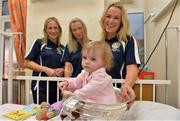 16 September 2013; Galway captain Lorraine Ryan, right, in the company of team-mates Therese Maher, left, and Orla Kilkenny with 13-month-old Zoe Garry, from Ballinteer, Dublin, and the O'Duffy Cup on a visit by the All-Ireland Senior & Intermediate Camogie Champions to Our Lady's Children's Hospital, Crumlin. Picture credit: Stephen McCarthy / SPORTSFILE
