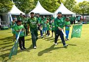10 May 2024; Pakistan captain Babar Azam, left, and Ireland captain Paul Stirling lead their side's out before match one of the Floki Men's T20 International Series between Ireland and Pakistan at Castle Avenue Cricket Ground in Dublin. Photo by Seb Daly/Sportsfile
