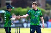 10 May 2024; Craig Young of Ireland, right, is congratulated by teammate Curtis Campher after claiming the wicket of Pakistan's Babar Azam during match one of the Floki Men's T20 International Series between Ireland and Pakistan at Castle Avenue Cricket Ground in Dublin. Photo by Seb Daly/Sportsfile