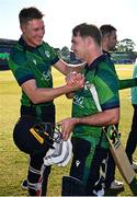 10 May 2024; Curtis Campher of Ireland, right, is congratulated by teammate Harry Tector after hitting the winning runs in their side's victory during match one of the Floki Men's T20 International Series between Ireland and Pakistan at Castle Avenue Cricket Ground in Dublin. Photo by Seb Daly/Sportsfile