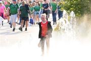 11 May 2024; A young Cork supporter cools off in a water feature on his way to the Munster GAA Hurling Senior Championship Round 3 match between Cork and Limerick at SuperValu Páirc Ui Chaoimh in Cork. Photo by Stephen McCarthy/Sportsfile