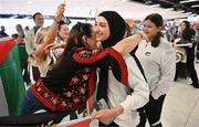 12 May 2024; Dina Abdeen of Palestine is greeted by Michelle Hayes, from Tipperary, on arrival at Dublin Airport as the Palestine women's national football team arrive in Ireland for an International Solidarity Match against Bohemians to be played on Wednesday at Dalymount Park in Dublin. Photo by Stephen McCarthy/Sportsfile