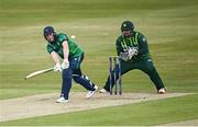 12 May 2024; Lorcan Tucker of Ireland plays a shot, watched by Pakistan wicket-keeper Azam Khan, during match two of the Floki Men's T20 International Series between Ireland and Pakistan at Castle Avenue Cricket Ground in Dublin. Photo by Seb Daly/Sportsfile