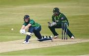 12 May 2024; Lorcan Tucker of Ireland plays a shot, watched by Pakistan wicket-keeper Azam Khan during match two of the Floki Men's T20 International Series between Ireland and Pakistan at Castle Avenue Cricket Ground in Dublin. Photo by Seb Daly/Sportsfile
