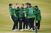 12 May 2024; Graham Hume of Ireland, centre, celebrates with teammates after taking the wicket of Pakistan's Babar Azam during match two of the Floki Men's T20 International Series between Ireland and Pakistan at Castle Avenue Cricket Ground in Dublin. Photo by Seb Daly/Sportsfile