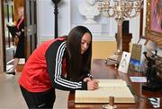 13 May 2024; Bohemians player Rachael Kelly signs the guest book on arrival for The President of Ireland Michael D Higgins to receive representatives of the Palestinian Football Association and Bohemian Football Club at Áras an Uachtaráin in Dublin. Palestine women's national football team are in Ireland for an International Solidarity Match against Bohemians women's team to be played on Wednesday, May 15, at Dalymount Park in Dublin. Photo by Stephen McCarthy/Sportsfile