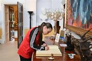 13 May 2024; Bohemians player Savannah Kane signs the guest book on arrival for The President of Ireland Michael D Higgins to receive representatives of the Palestinian Football Association and Bohemian Football Club at Áras an Uachtaráin in Dublin. Palestine women's national football team are in Ireland for an International Solidarity Match against Bohemians women's team to be played on Wednesday, May 15, at Dalymount Park in Dublin. Photo by Stephen McCarthy/Sportsfile