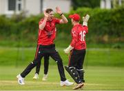 15 May 2024; Josh Manley of Munster Reds celebrates with team-mate Oliver Metcalfe after taking the wicket of Philippe Le Roux of Leinster Lightning during the Inter-Provincial IP50 Cup match between Leinster Lightning and Munster Reds at Sydney Parade, Sandymount in Dublin. Photo by Matt Browne/Sportsfile