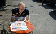 19 May 2024; A Clare supporter reads his Sunday Independent, outside The Food Emporium, on Francis Street, in Ennis, before the Munster GAA Hurling Senior Championship Round 4 match between Clare and Waterford at Cusack Park in Ennis, Clare. Photo by Ray McManus/Sportsfile