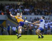 19 May 2024; Jamie Barron of Waterford scores a point despite the efforts of Cian Galvin of Clare during the Munster GAA Hurling Senior Championship Round 4 match between Clare and Waterford at Cusack Park in Ennis, Clare. Photo by John Sheridan/Sportsfile