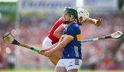 19 May 2024; Darragh Stakelum of Tipperary watches his shot as Tim O'Mahony of Cork comes to challenge during the Munster GAA Hurling Senior Championship Round 4 match between Tipperary and Cork at FBD Semple Stadium in Thurles, Tipperary. Photo by Brendan Moran/Sportsfile