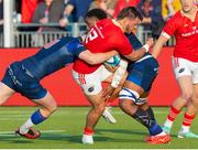 17 May 2024; Alex Nannkivell of Munster is tackled by Ben Healy, left, and Vilaime Mata, right, of Edinburgh during the United Rugby Championship match between Edinburgh and Munster at the Hive Stadium in Edinburgh, Scotland. Photo by Mark Scates/Sportsfile