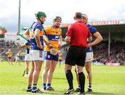 26 May 2024; Referee Johnny Murphy prepares to hand out yellow cards to Noel McGrath of Tipperary, left, Tony Kelly of Clare, and Bryan O'Mara of Tipperary during the Munster GAA Hurling Senior Championship Round 5 match between Tipperary and Clare at FBD Semple Stadium in Thurles, Tipperary. Photo by Michael P Ryan/Sportsfile
